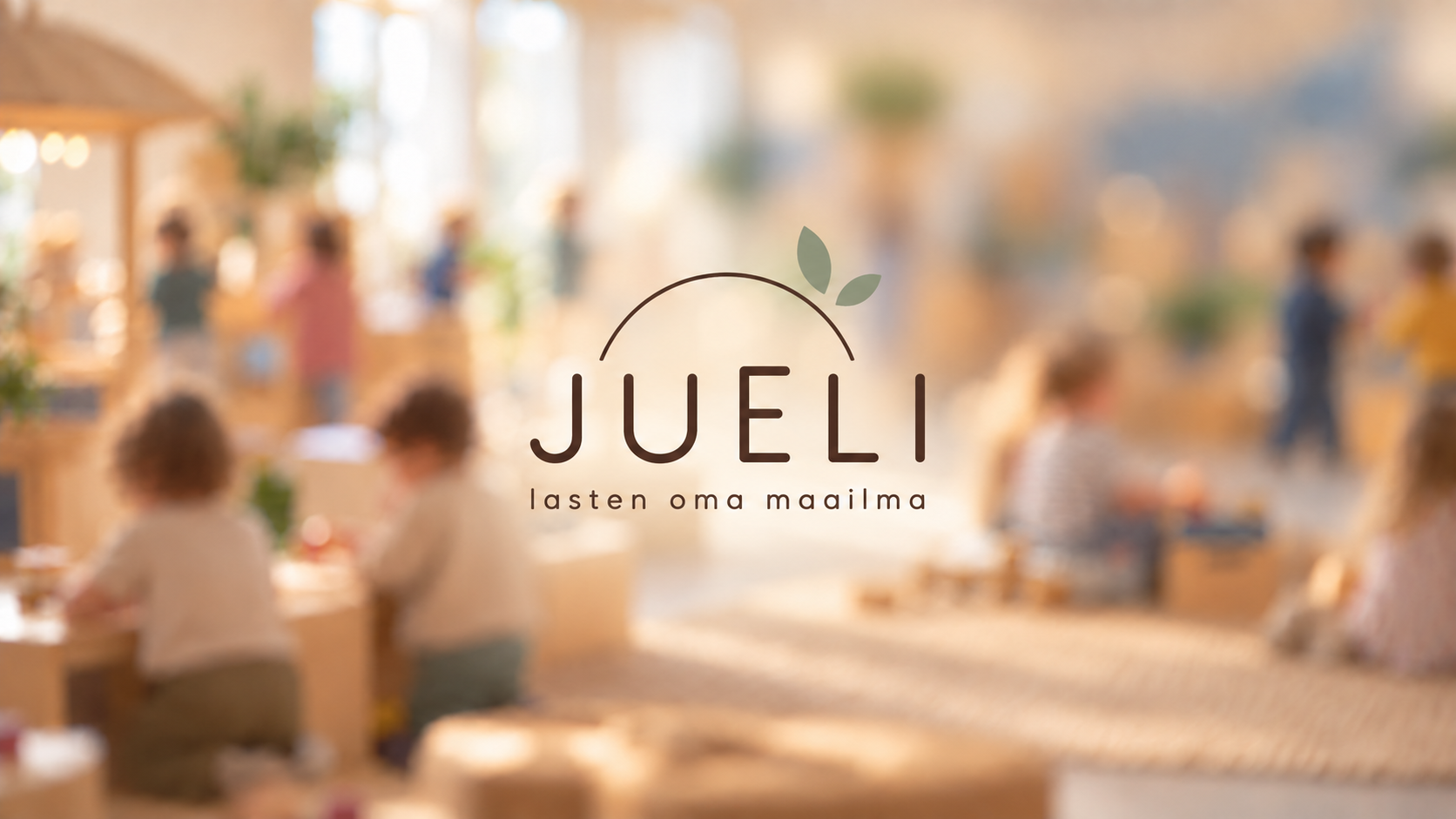 Juelin logo keskellä kuvaa, jonka sumeassa taustassa lapset leikkivät.